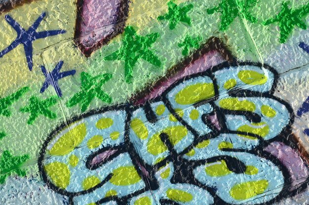 Foto fragment von graffiti-zeichnungen die alte wand ist mit farbflecken im stil der street-art-kultur geschmückt farbige hintergrundtextur in grünen tönen