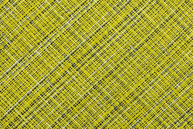 Un fragmento de una alfombra de paja, como fondo o textura, color amarillo y gris, primer plano.