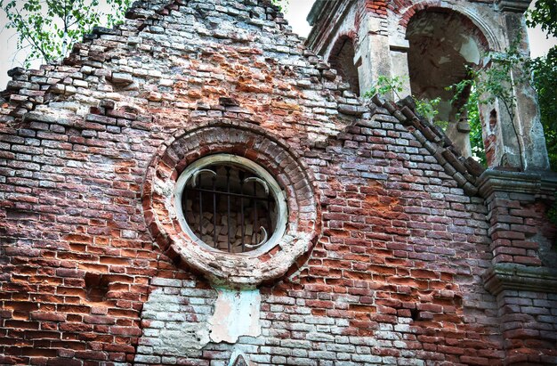 Fragmento de un antiguo muro de iglesia con ventana y celosía.