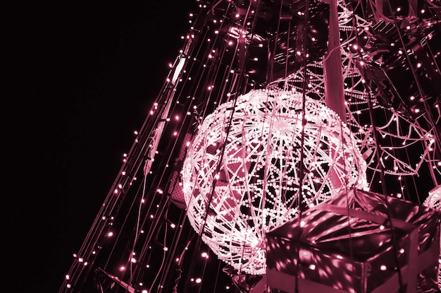 Fragmento del árbol de Año Nuevo Muchas luces redondas de color azul están ubicadas en un marco cónico Imagen tonificada en el color Viva Magenta del año