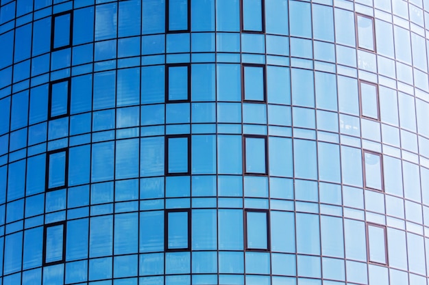 Un fragmento de una casa moderna con grandes ventanales que muestra un cielo azul. Arquitectura moderna con construcciones de vidrio_
