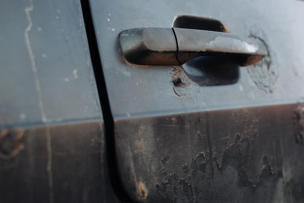 Un fragmento del cuerpo de una puerta de coche oxidada con un asa Corrosión agresiva Vista inferior