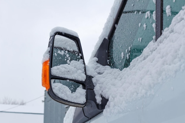 Foto fragmento da cabine coberta de neve do caminhão em um fundo de céu nublado de inverno