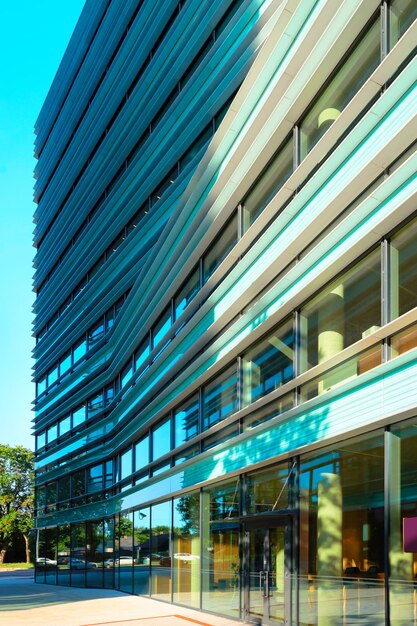 Fragmento de arquitetura comercial de arranha-céus modernos de metal e vidro refletindo o céu azul