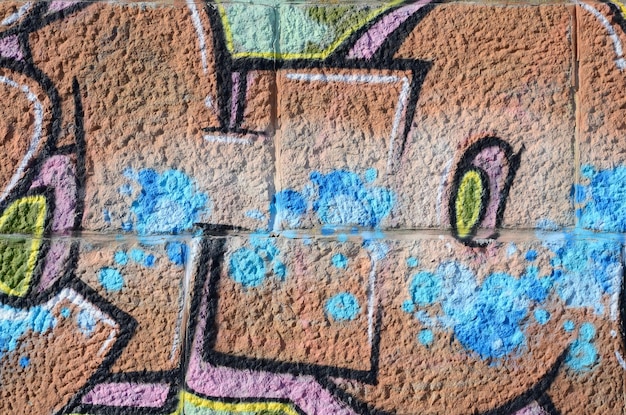 Fragmento de desenhos de graffiti a parede velha decorada com manchas de tinta no estilo da cultura de arte de rua textura de fundo colorido em tons quentes