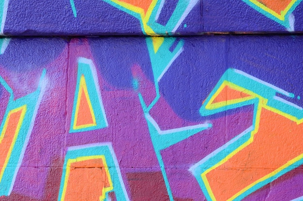 Fragmento de desenhos de graffiti A parede velha decorada com manchas de tinta no estilo da cultura de arte de rua Textura de fundo colorido em tons roxos