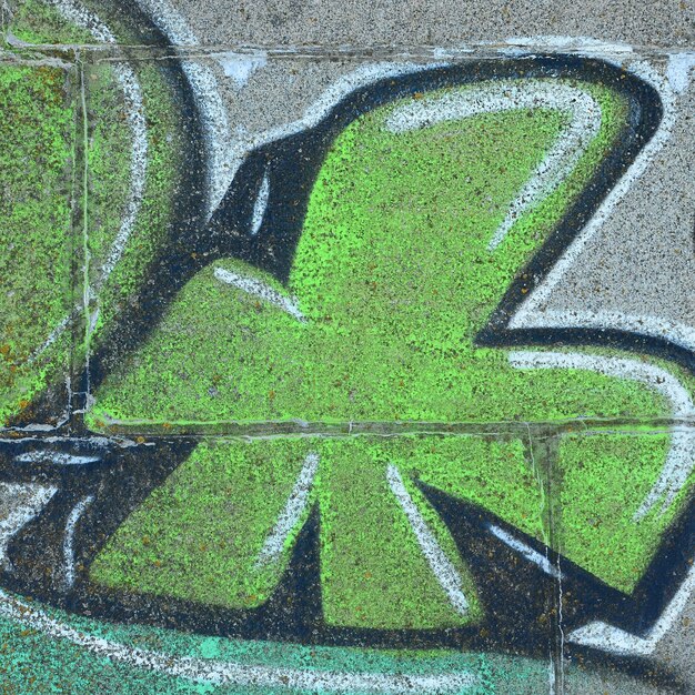 Foto fragmento de desenhos de graffiti a velha parede decorada com manchas de pintura no estilo da cultura da arte de rua textura de fundo colorida em tons verdes