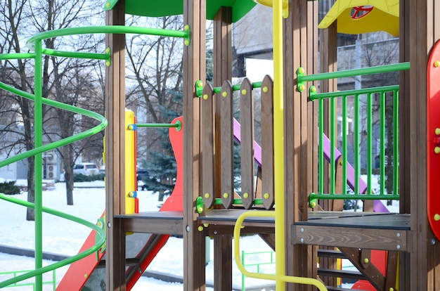 Fragmento de um parque infantil de plástico e madeira, pintado em cores diferentes