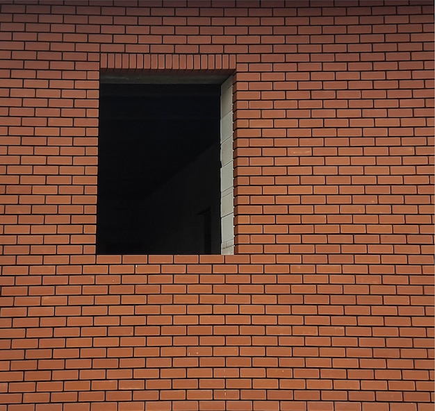 Fragmento de uma parede de tijolos vermelhos com uma janela vazia