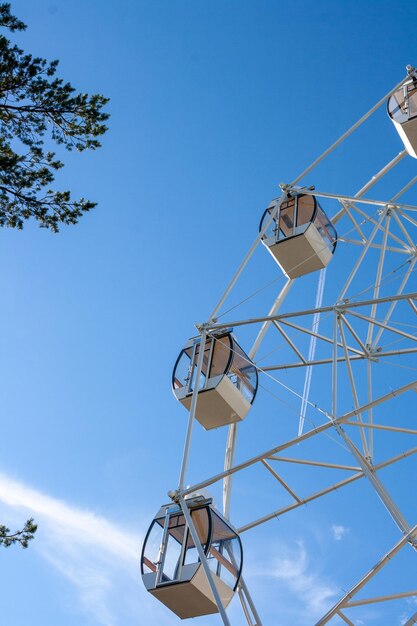 Fragmento de uma roda gigante em um fundo de céu azul e nuvens