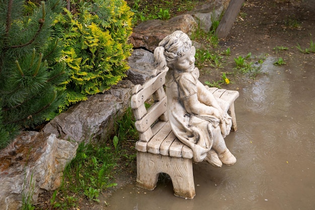 Fragmento do parque com escultura de jardim e paisagismo de plantas