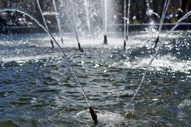 Fragmento de la fuente de la ciudad con chorros y salpicaduras de agua, día soleado de verano