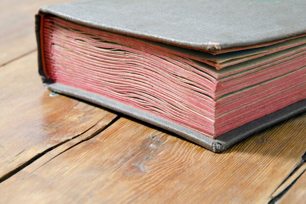 Fragmento de libro antiguo tendido sobre la superficie de madera desgastada