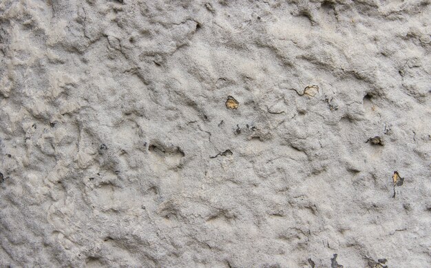 Fragmento de la pared de yeso texturado cubierto con pintura gris.