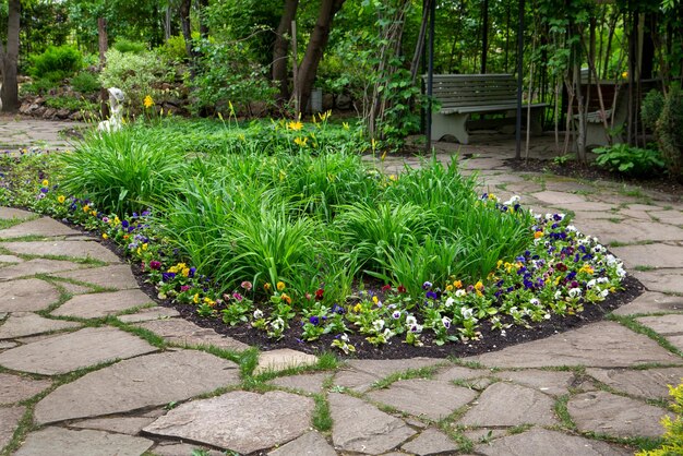 Fragmento de un parque paisajístico con macizos de flores y caminos empedrados