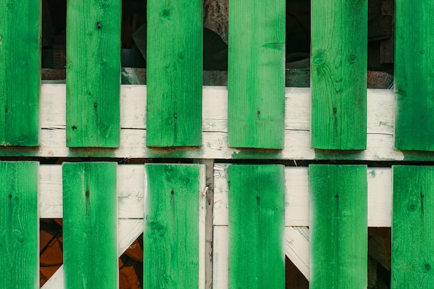 Fragmento de puertas de granero de tablones largos de color verde vivo de cerca. Almacenamiento de leña en cobertizo detrás de puertas de madera con espacio de copia. Estilo de vida rústico. Fondo detallado texturizado de la construcción del grunge.