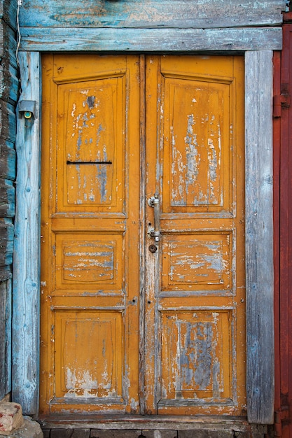 Fragmento de una valla hecha de viejas tablas de madera con restos de pintura y textura natural de uñas