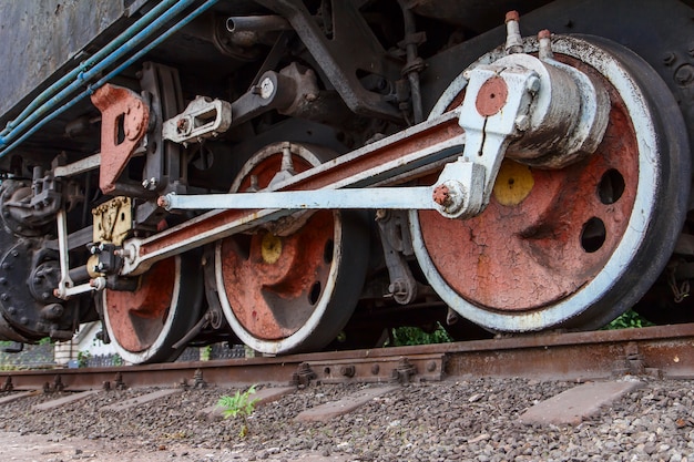 Fragmento de una vieja locomotora oxidada de pie sobre las vías del tren