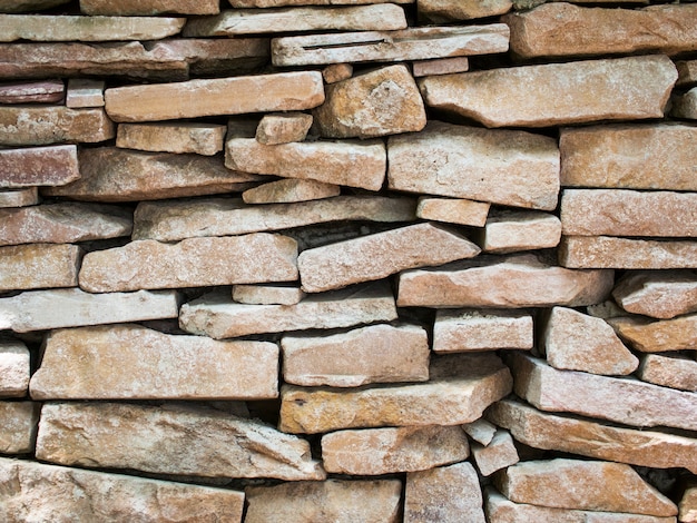 Foto fragmentos de piedra en la pared sellados con mortero de cemento.