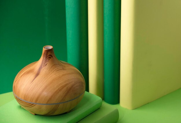 fragrância de madeira sobre a mesa, com vapor de essência de óleos naturais, mãos de homem com livros vários esverdeados.