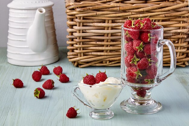 Framboesas frescas maduras e chantilly em um copo de vidro