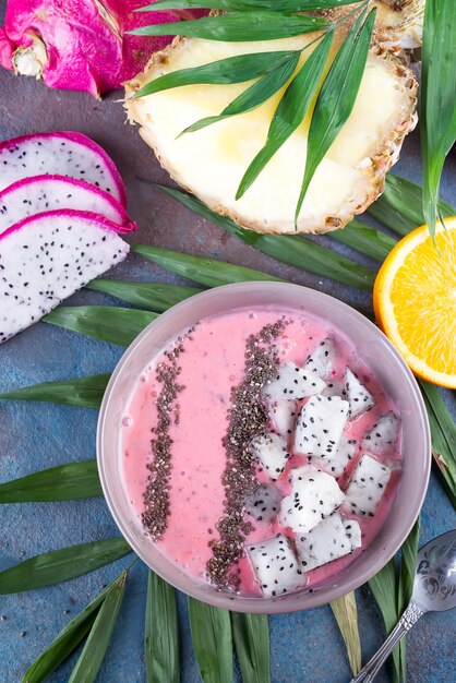 Framboesas vermelhas ou rosa smoothie tigelas cobertas com sementes frescas de pitaya e chia na palma da mão sobre fundo de pedra, cópia espaço