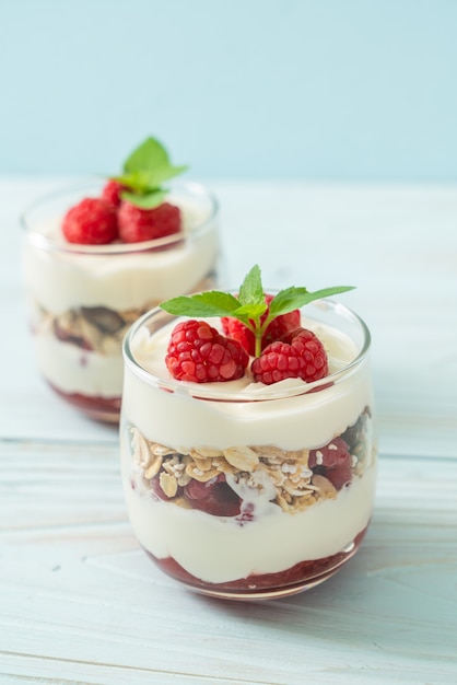 Foto frambuesa fresca y yogur con granola - estilo de comida saludable