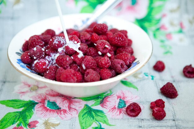 Frambuesa roja fresca de verano en el plato en casa