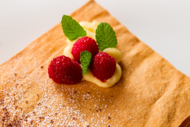 Frambuesas y hojas de menta. Pastelería con polvo blanco. Receta sencilla de bizcocho crujiente. Endulza tu vida.