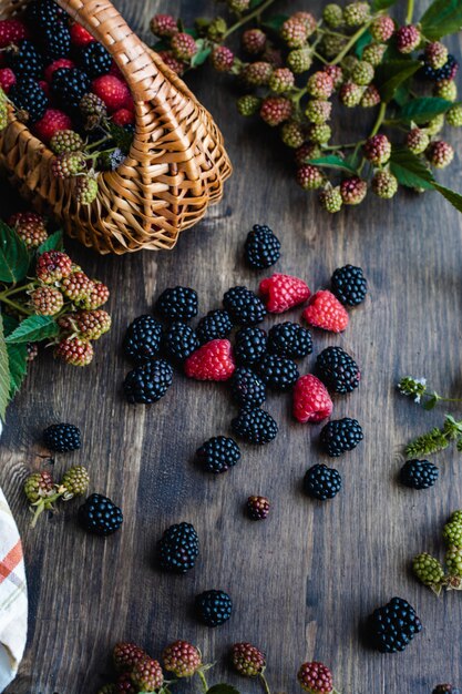 Frambuesas y moras frescas maduras con cesta de paja