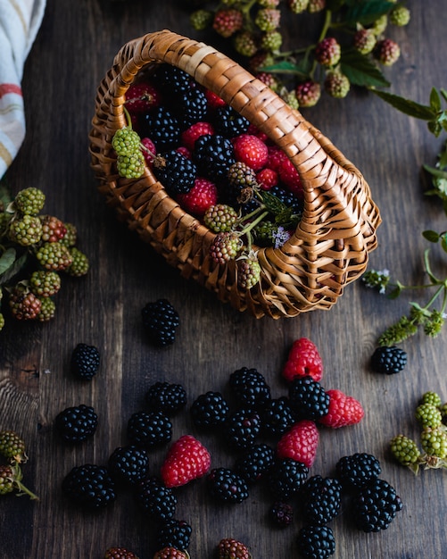 Frambuesas y moras frescas maduras con cesta de paja