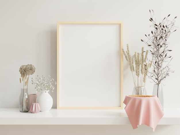 Frame de madeira encostado na prateleira branca no interior brilhante com plantas na mesa com plantas em vasos na parede vazia.