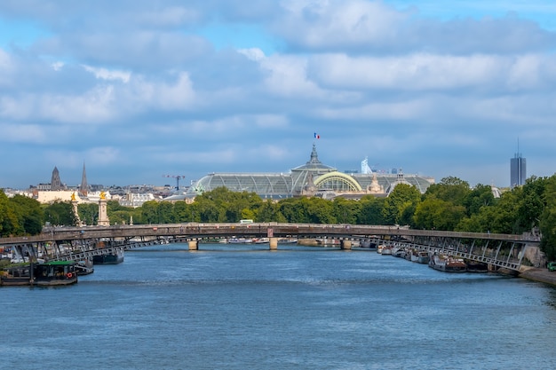 França. Dia de verão em Paris. Céu nublado sobre o Sena. Telhado de vidro do Grande Palácio