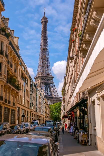 Foto frança. paris. rua estreita da cidade em tempo ensolarado de verão. a torre eiffel