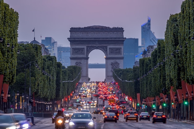 Francia. París. Tráfico denso en los Campos Elíseos. Arco triunfal. Oscuridad