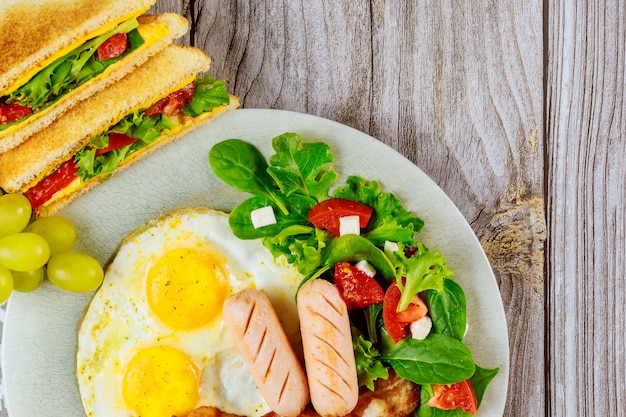 Francos, huevos fritos, sándwiches de queso a la parrilla y ensalada para el desayuno.