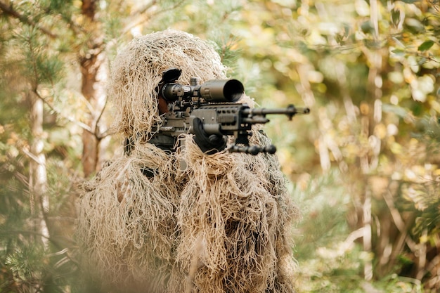 Un francotirador camuflado apuntando a través de su alcance