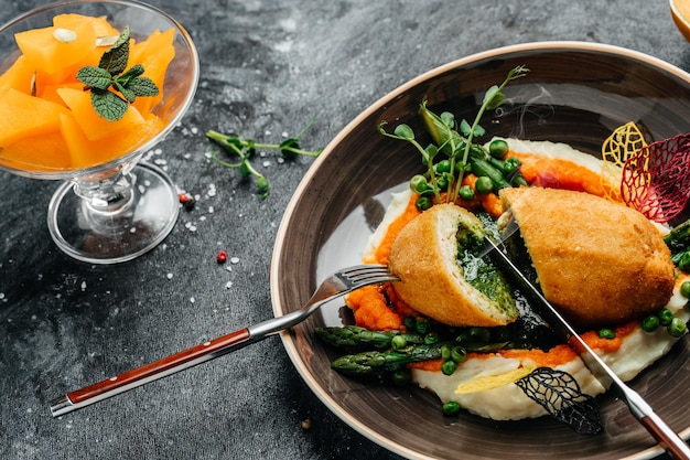 Frango à kiev, peito de frango à milanesa recheado com ervas e manteiga. peito de costeleta com purê de batata e abóbora