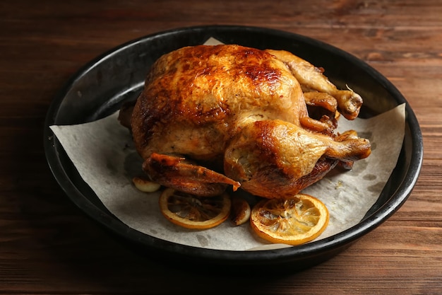 Frango assado caseiro com limão na mesa de madeira