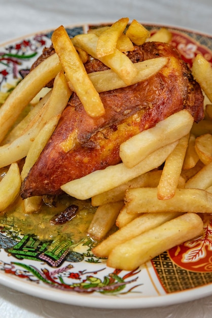 Foto frango assado com batatas fritas em um prato