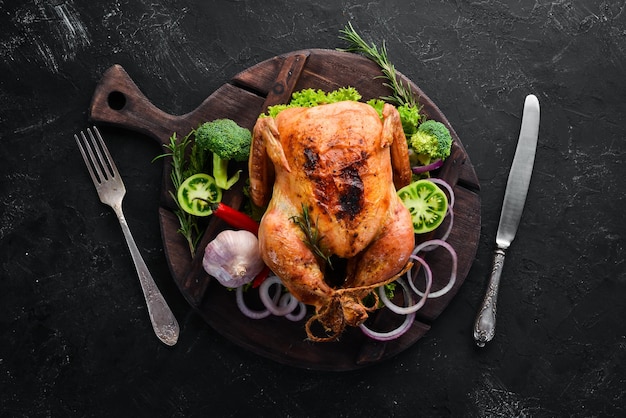 Frango assado com especiarias em um fundo preto O prato tradicional de Ação de Graças Vista superior Espaço para cópia gratuita