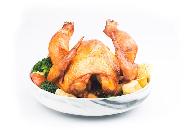 Frango assado com legumes na mesa branca