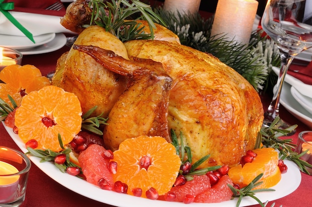 Frango assado com tangerina, toranja e romã na mesa de Natal