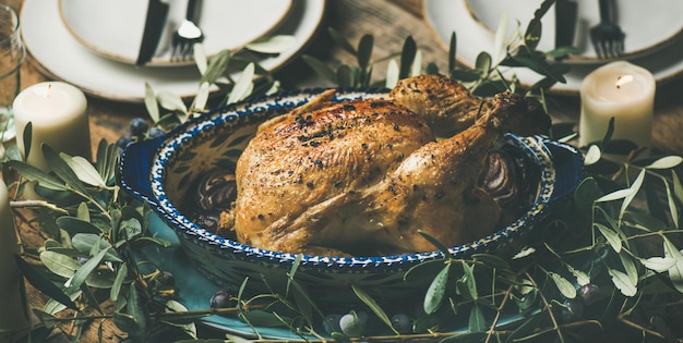 Frango assado inteiro decorado com foco seletivo de ramo de oliveira