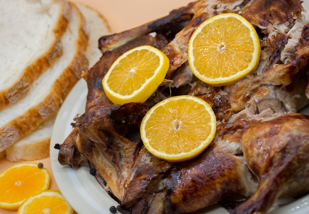 frango assado inteiro ou pato em prato branco decorado com laranjas frescas e pão