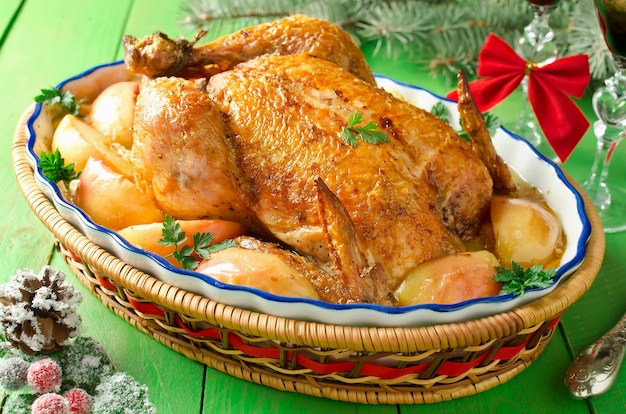 Frango assado inteiro recheado com maçãs, em molho cremoso e rodelas de maçãs. ceia de Natal