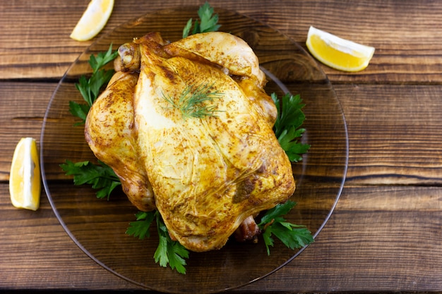 Frango assado na mesa de madeira. Almoço festivo para as férias. Frango cozido em casa