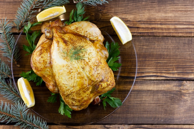 Frango assado na mesa de madeira. Almoço festivo para as férias. Frango cozido em casa