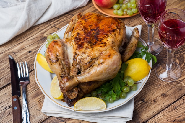 Frango assado, purê de batatas e taças de vinho para o jantar na mesa festiva.