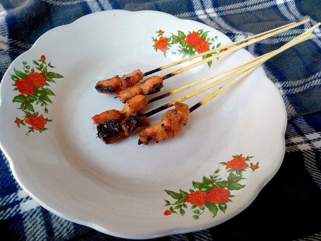 Foto frango balinesa satay no prato culinária indonésia